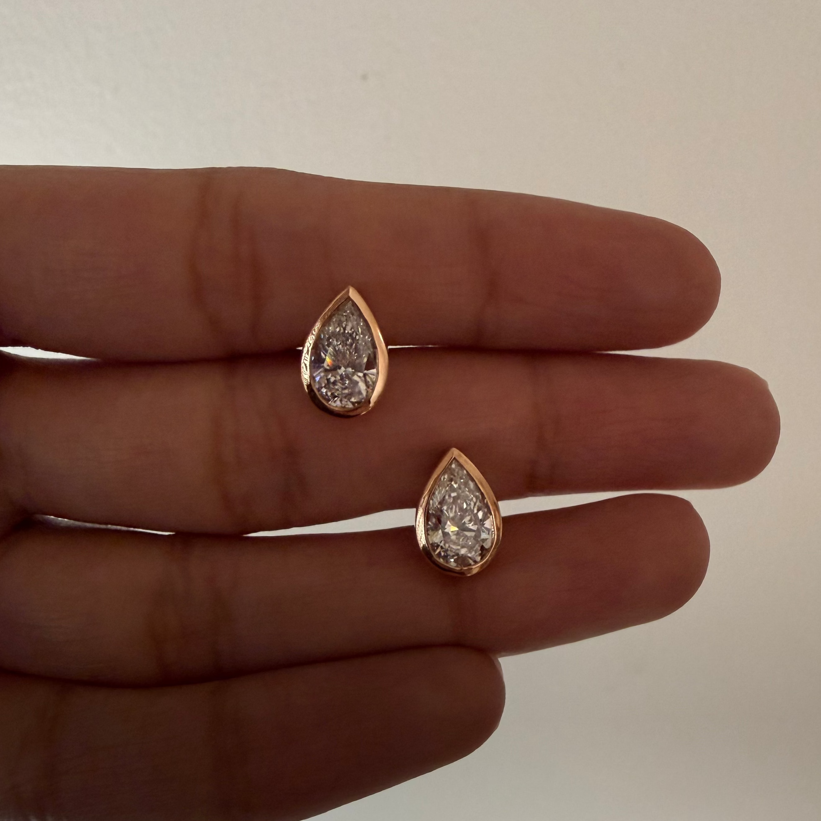 pear shaped diamond solitaire earrings with a 18kt solid gold bezel in rose gold