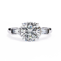 trilogy ring features a magnificent Cushion-cut solitaire flanked by two tapering baguette diamonds