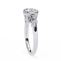 trilogy ring features a magnificent Cushion-cut solitaire flanked by two tapering baguette diamonds