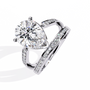 ring features a commanding Pear solitaire framed by two distinct architectural bands one linear and one curved both encrusted with Pavé diamonds