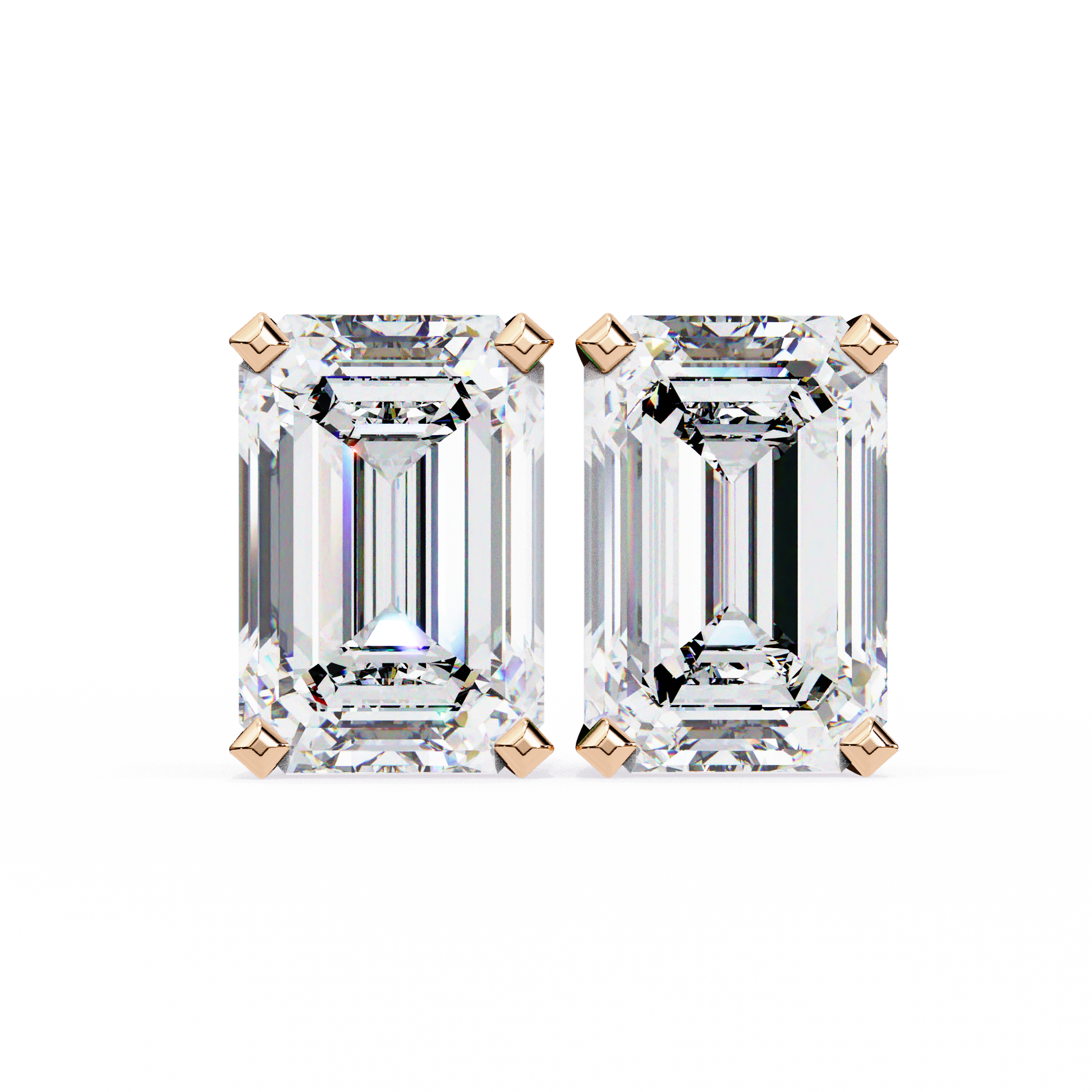 Pair of emerald-cut diamonds with rose gold prongs on a white background
