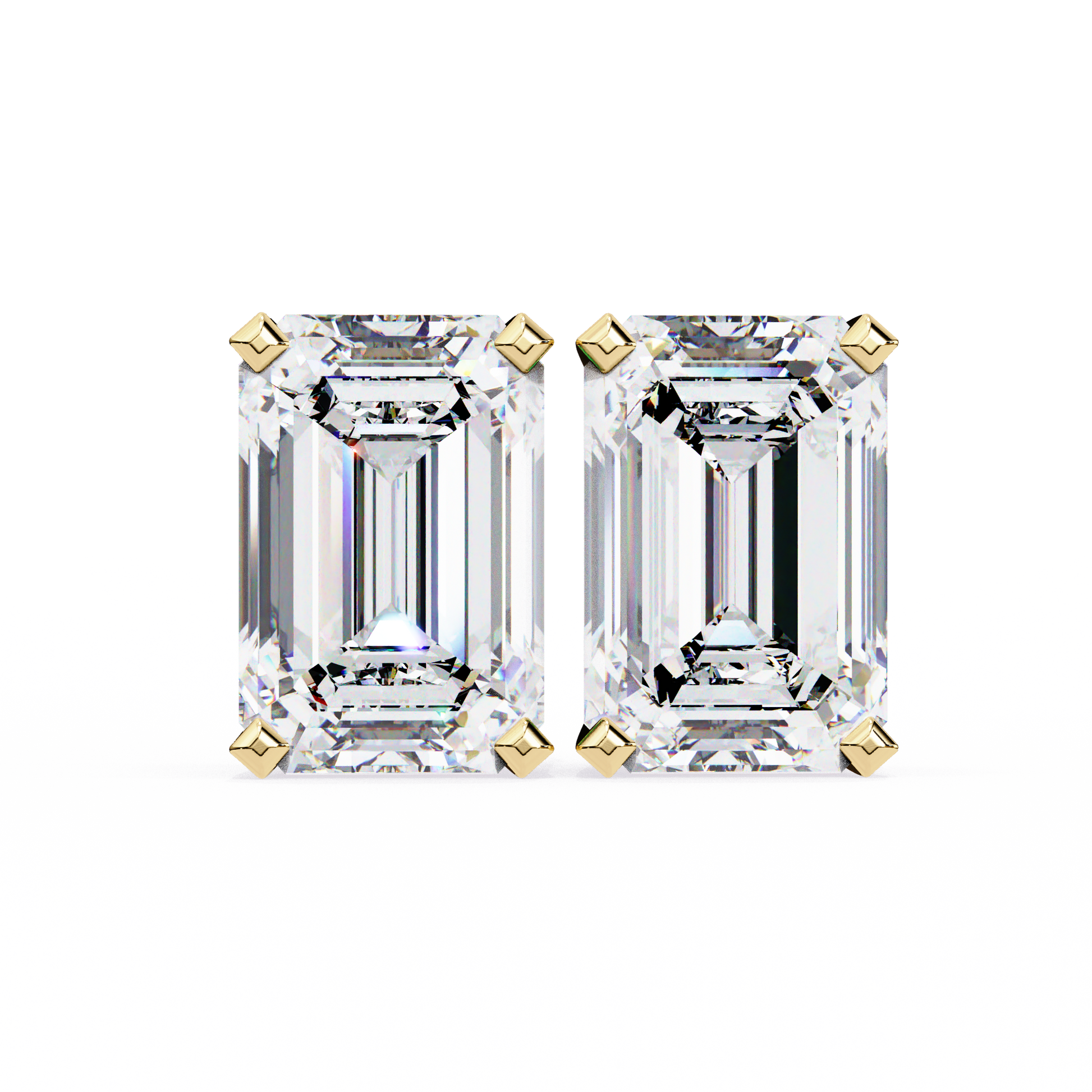 Pair of emerald-cut diamonds with gold prongs on a white background