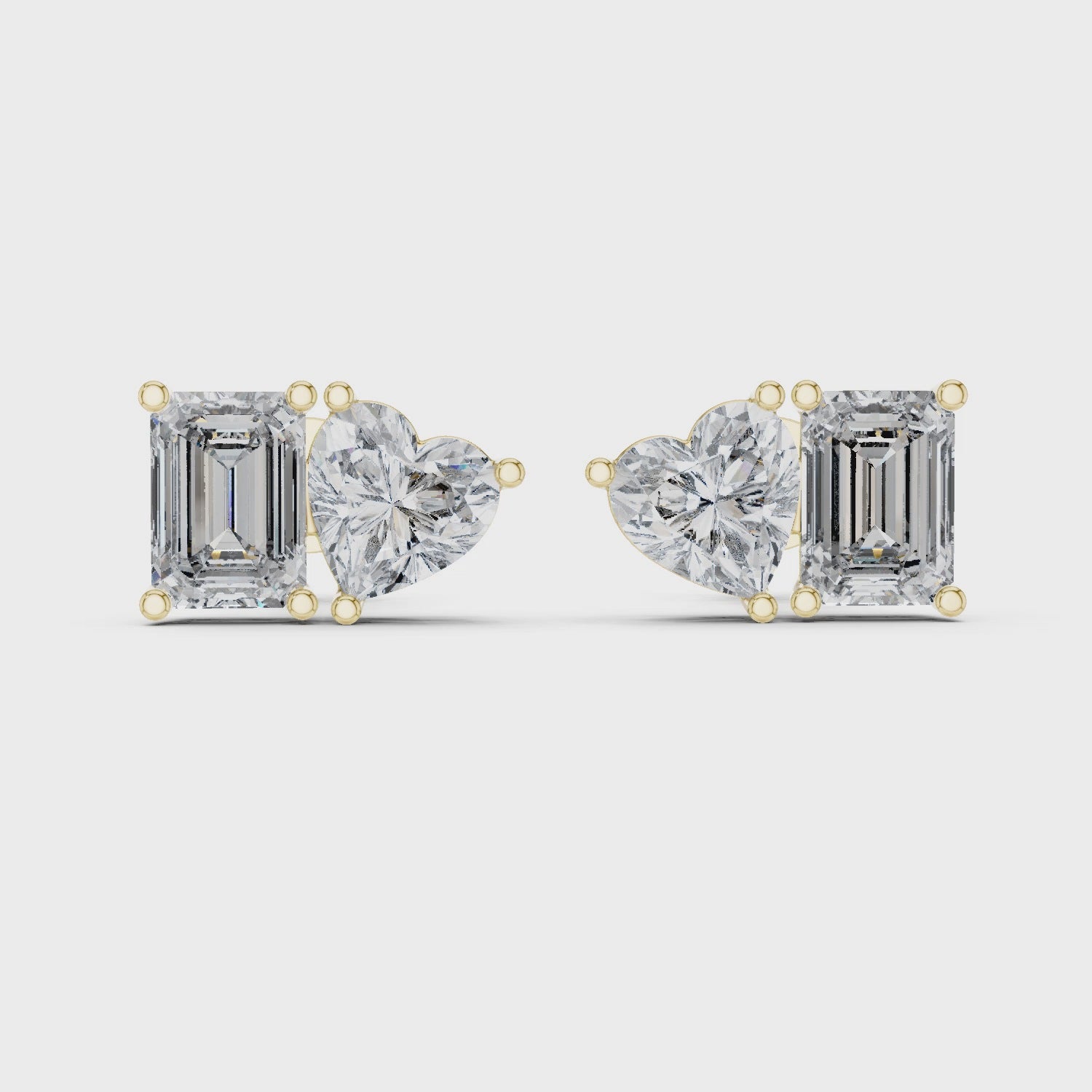 Diamond earrings with emerald-cut and heart-shaped stones on a white background