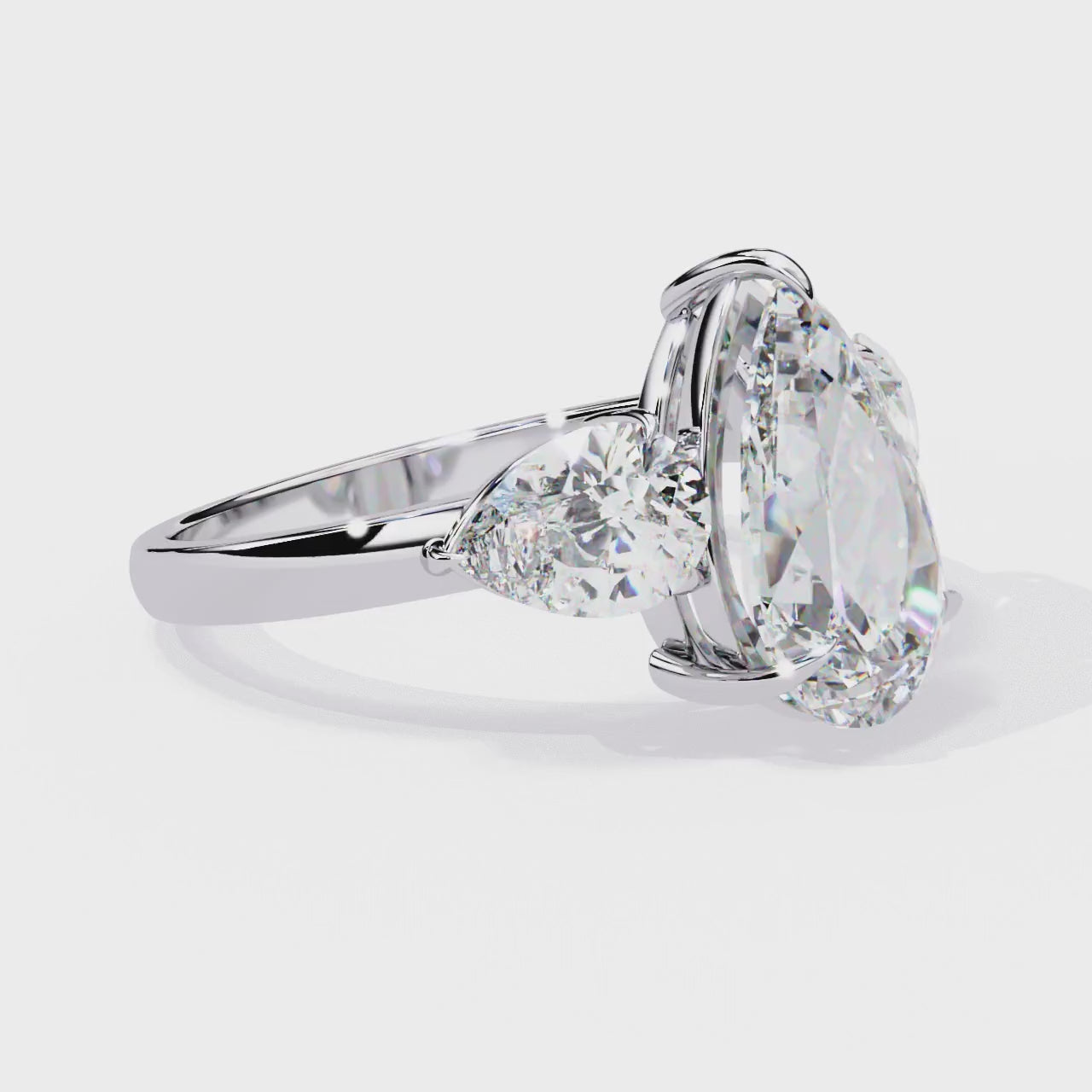 trilogy ring showcases a substantial Pear centre flanked by two perfectly matched pear-shaped side stones