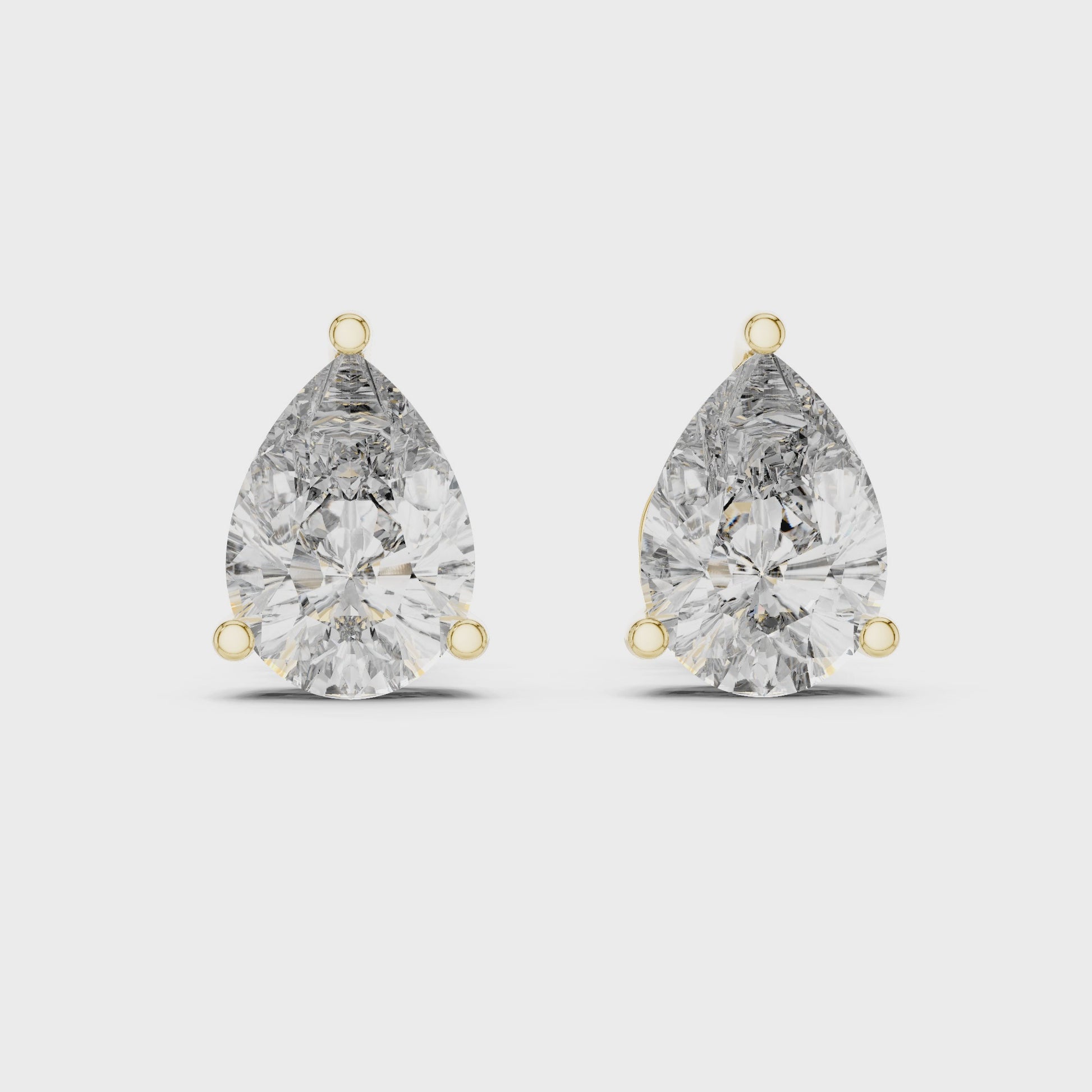 Pair of pear-shaped diamond earrings on a white background