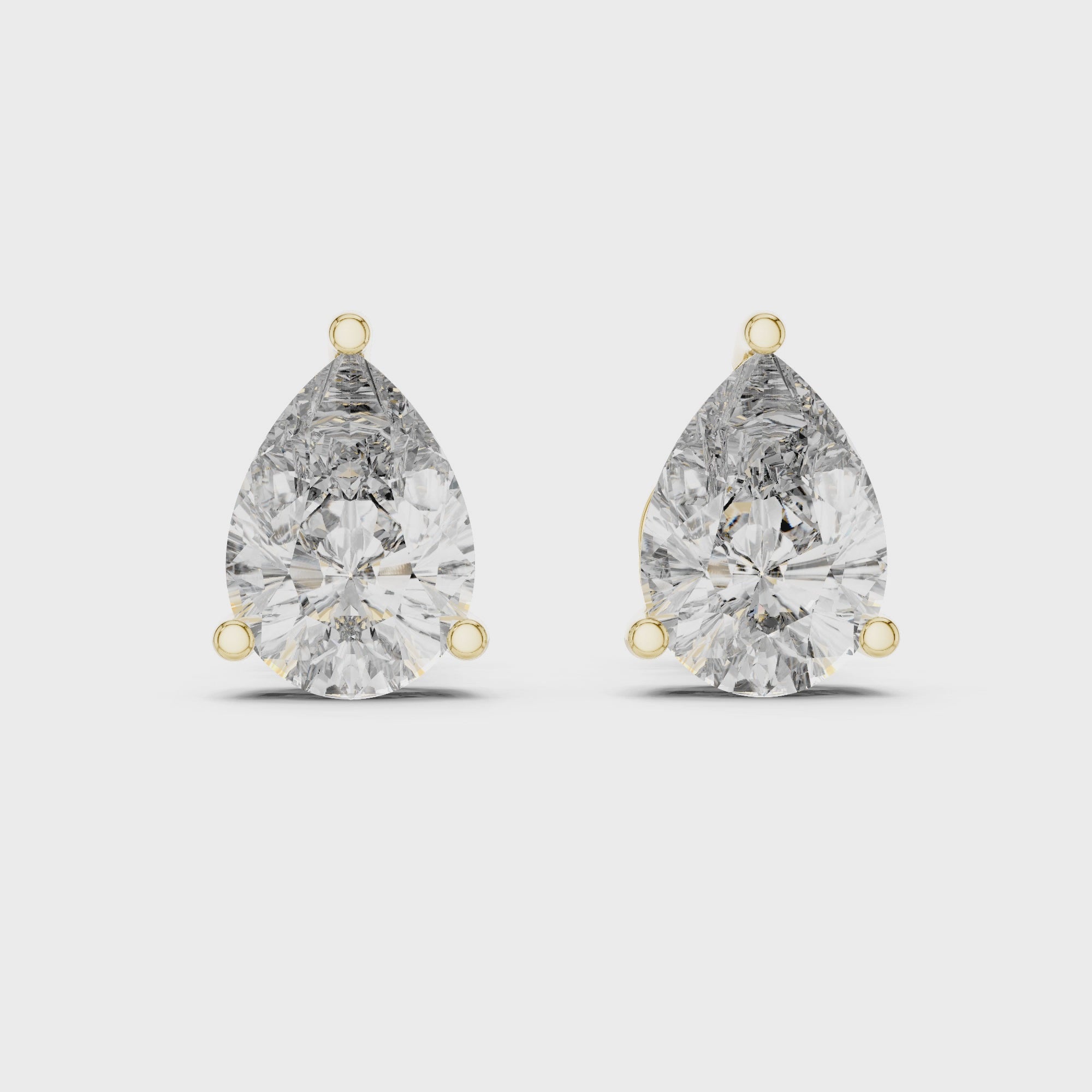Pair of pear-shaped diamond earrings on a white background
