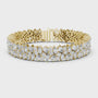 Gold bracelet with pear and marquise diamonds on a white background