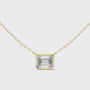 Gold necklace with a emerald pendant on a white background