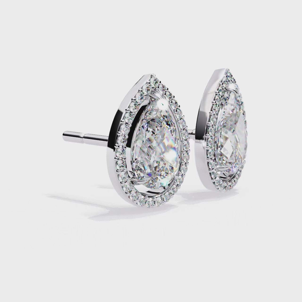 Teardrop-shaped diamond earrings with gold and clear gemstones on a white background