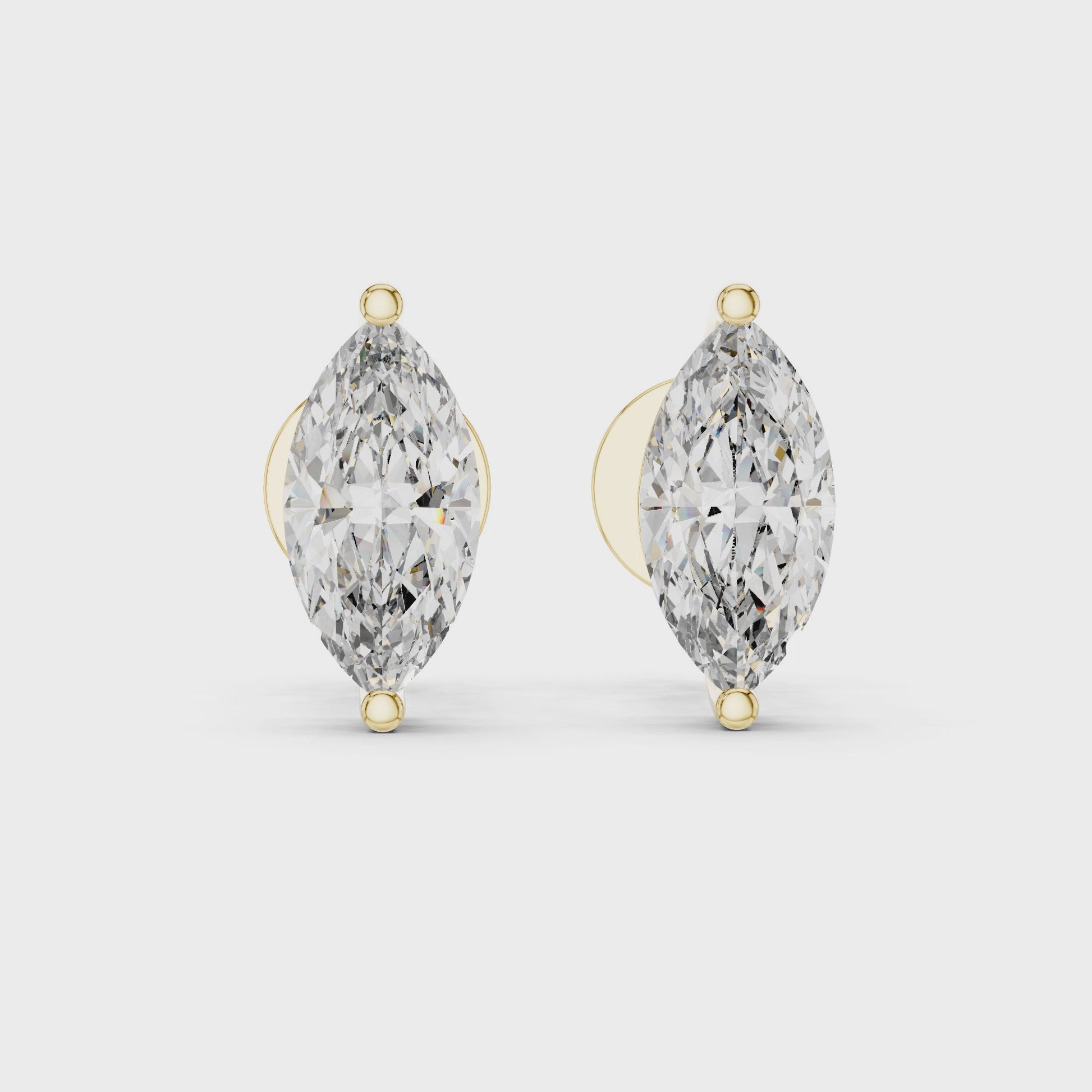Pair of marquise-shaped diamond earrings with gold accents on a white background