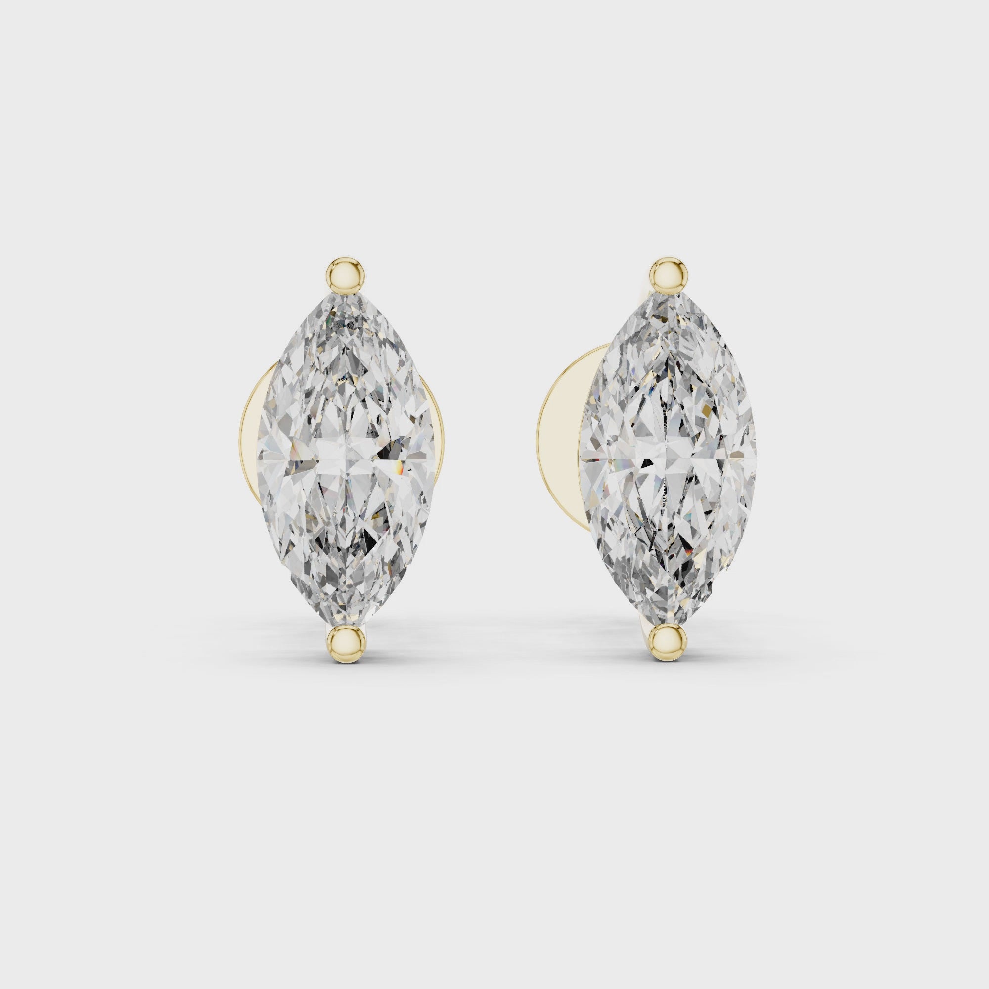 Pair of marquise-shaped diamond earrings with gold accents on a white background