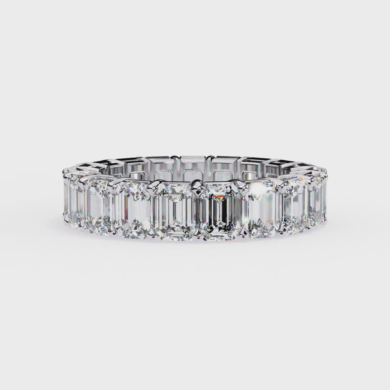 "tennis ring" features a continuous circle of magnificent Emerald-cut diamonds set vertically