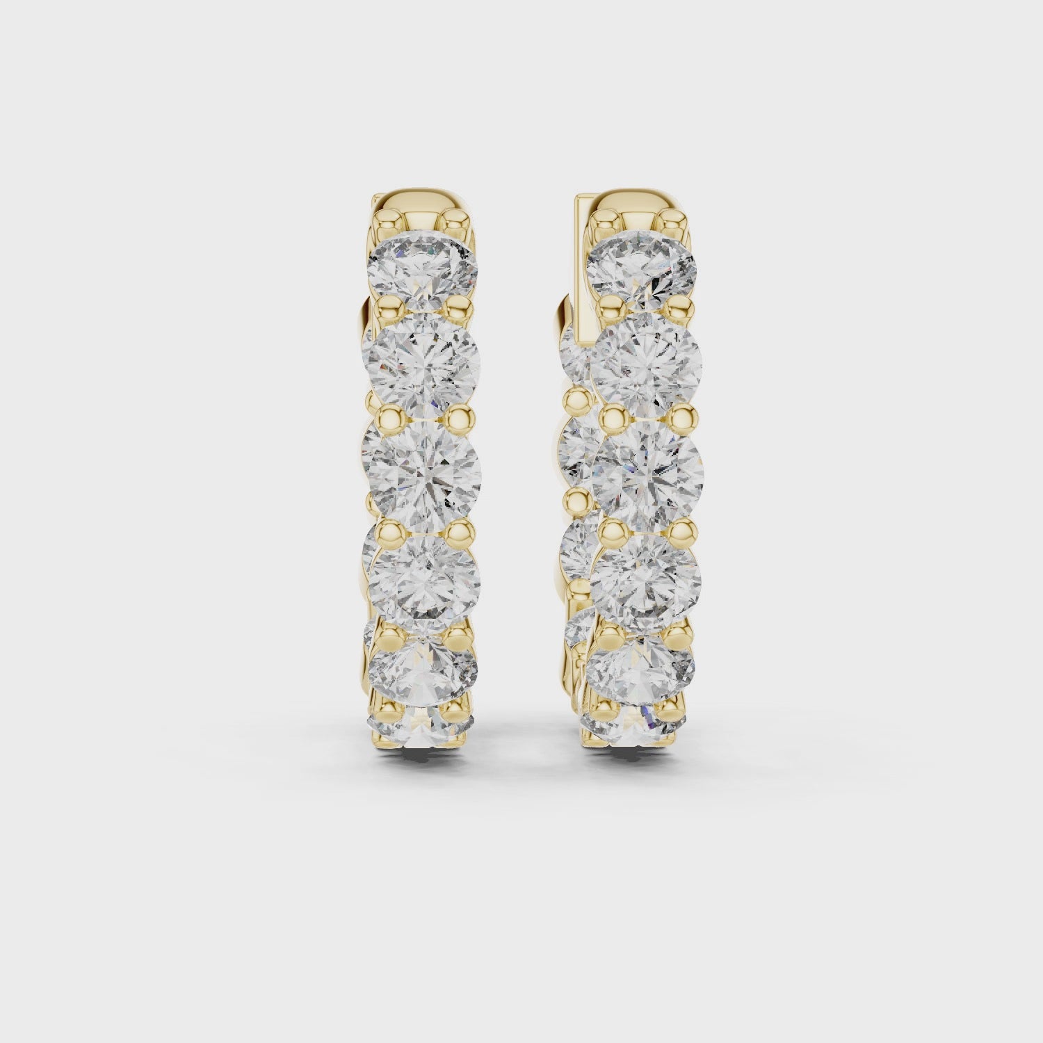 Gold hoop earrings with diamonds on a white background