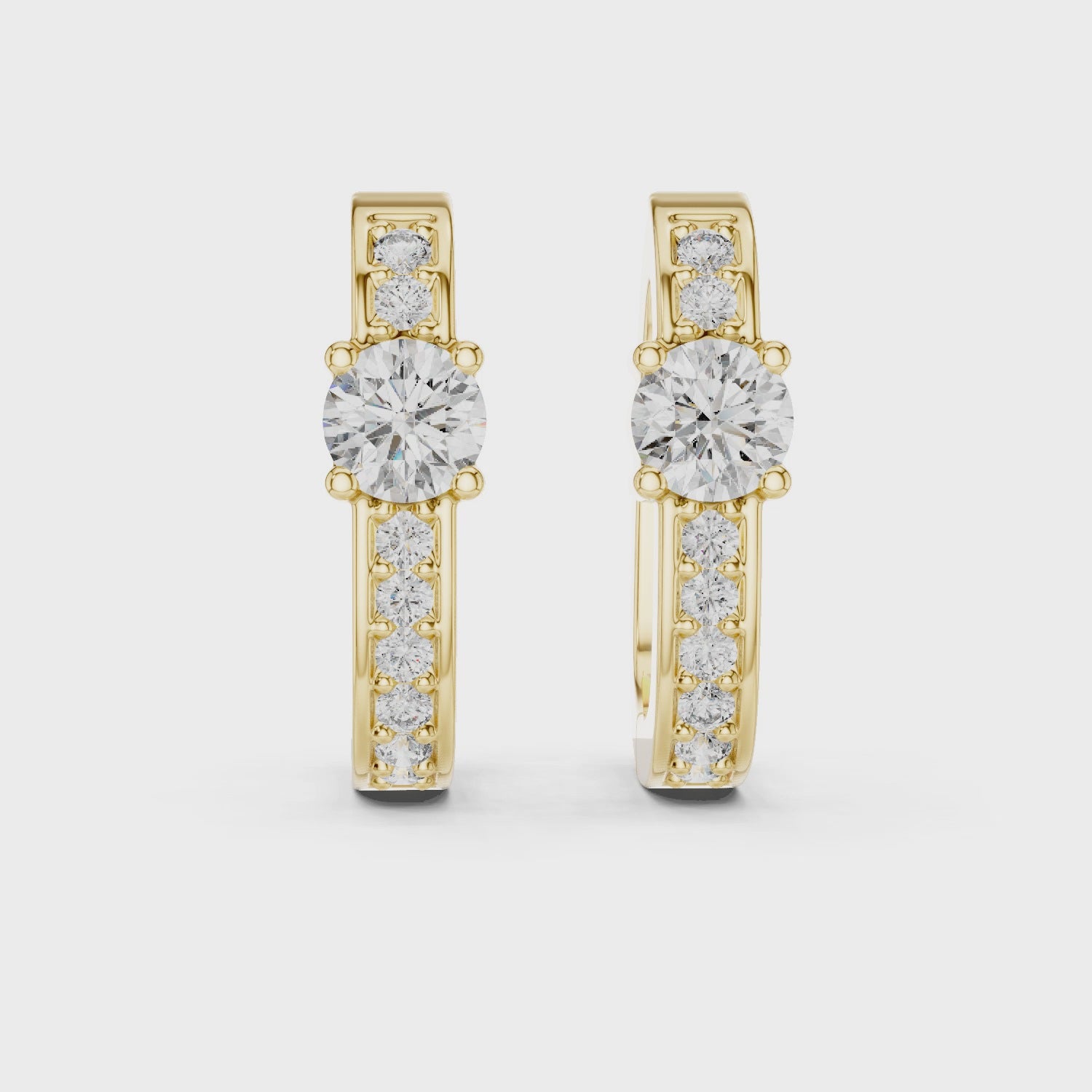 Gold earrings with diamond accents on a white background