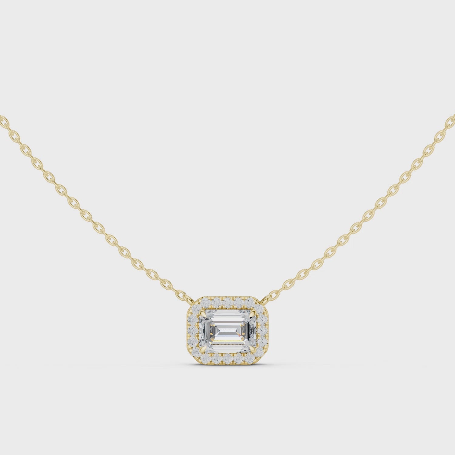 Gold necklace with a emerald diamond pendant on a white background