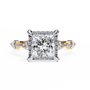 ring features a brilliant Princess-cut diamond framed by a delicate halo of round diamonds