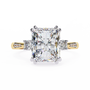 ring features a commanding Radiant-cut solitaire flanked by two brilliant Round diamonds