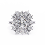 ring showcases a brilliant Radiant-cut diamond framed by an exquisite floral-inspired cluster halo